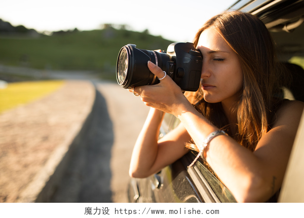 探出车窗拍照的年轻女人女人照片 